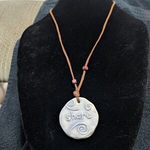 handmade ceramic or clay pendant with the word "share". Boho Ceramic Pendant